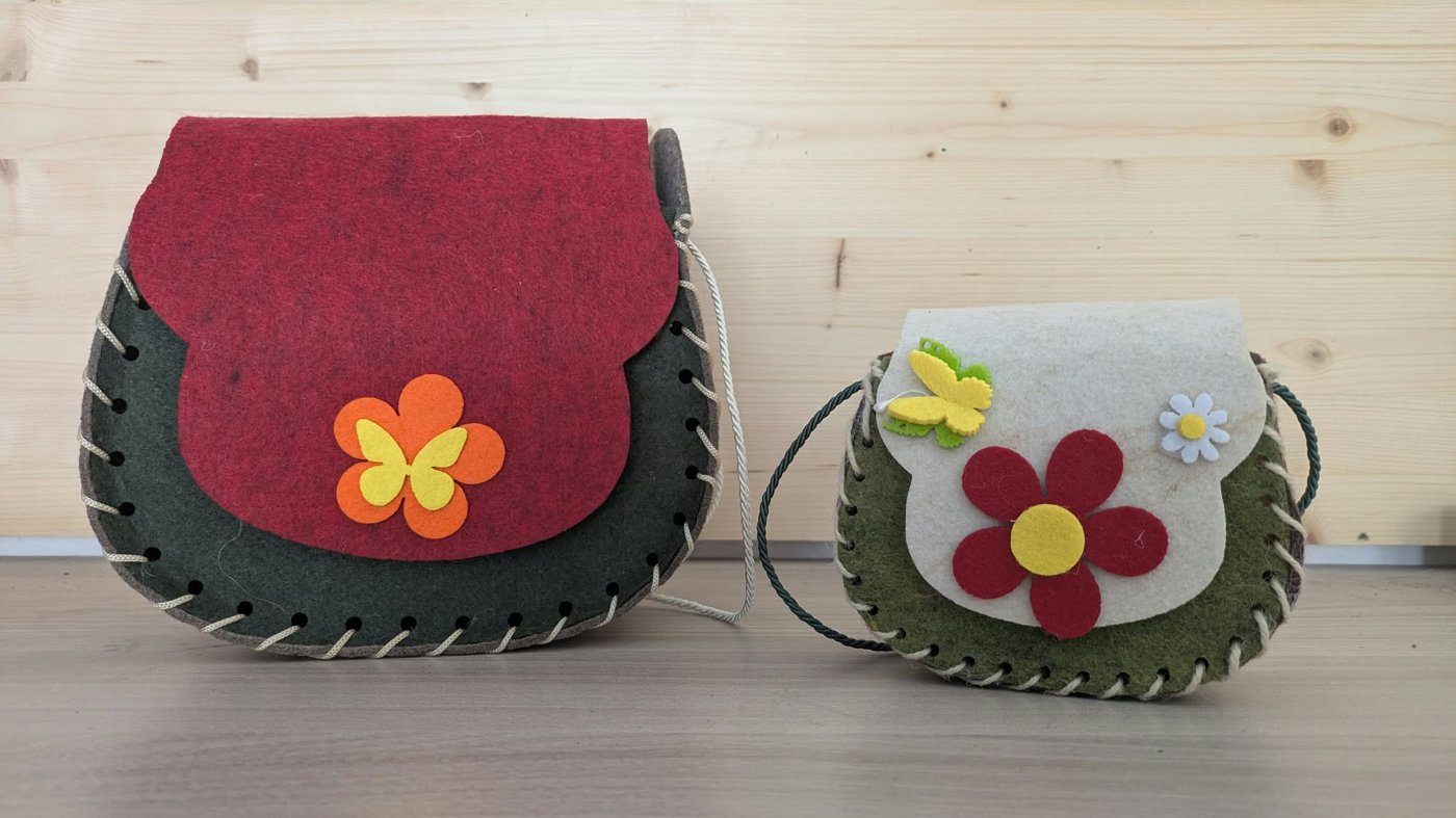 Due borsette in feltro intrecciate a mano, decorate con fiori e farfalle